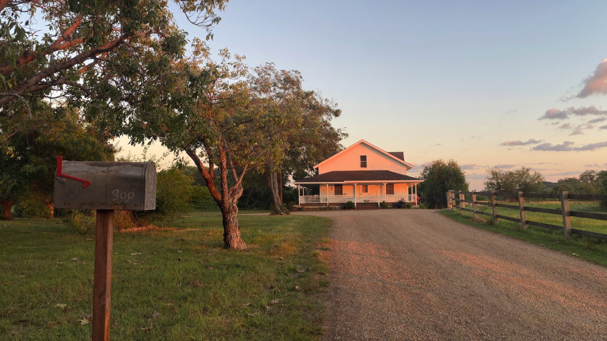 White farmhouse and mailbox on a country road at golden hour near Perry, Georgia, symbolizing passing the family estate to heirs