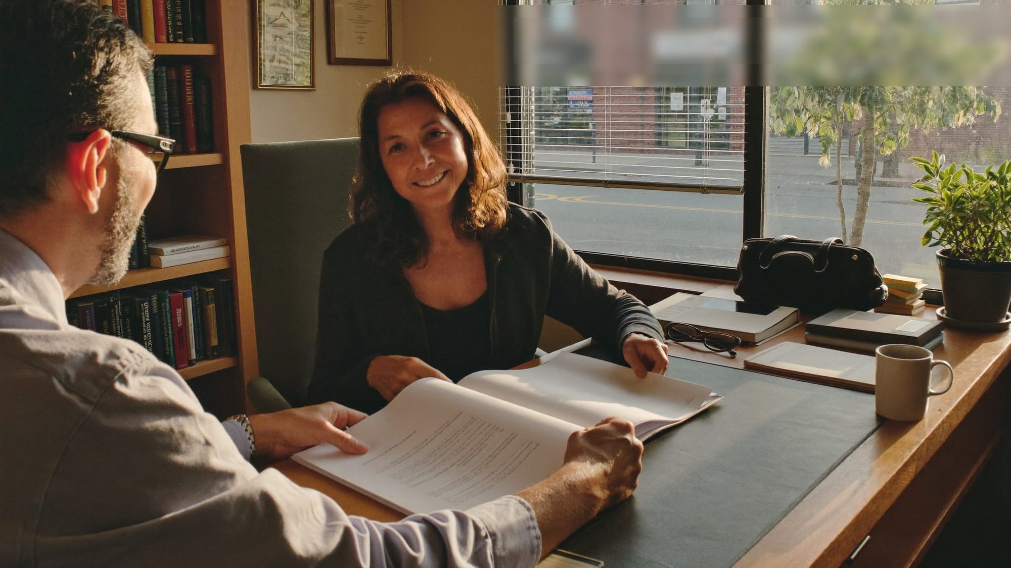 Georgia woman in her late 50s reviewing inherited IRA paperwork with an accountant in a small-town office